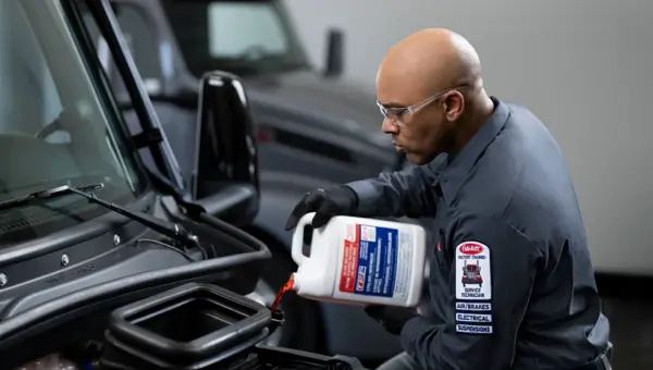 Image of a technician pouring coolant