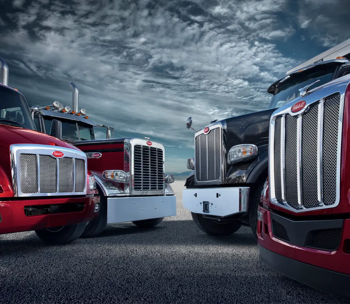 __A fleet of trucks wait under a cloudy sky
